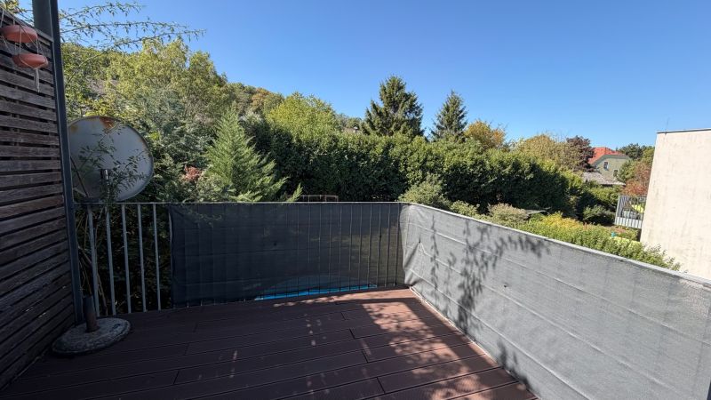 The balcony of a 3-room apartment in Wolfsthal with a view of greenery and a satellite dish.