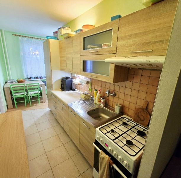 A kitchen in a 4-room apartment with a wooden decor and a dining nook.