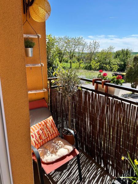 A balcony in a 3-room apartment with a comfortable chair and a view of greenery in Veľký Lapáš.
