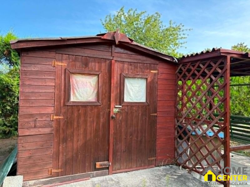 A wooden garden house with a covered shelter in the Gardens of Komárno.