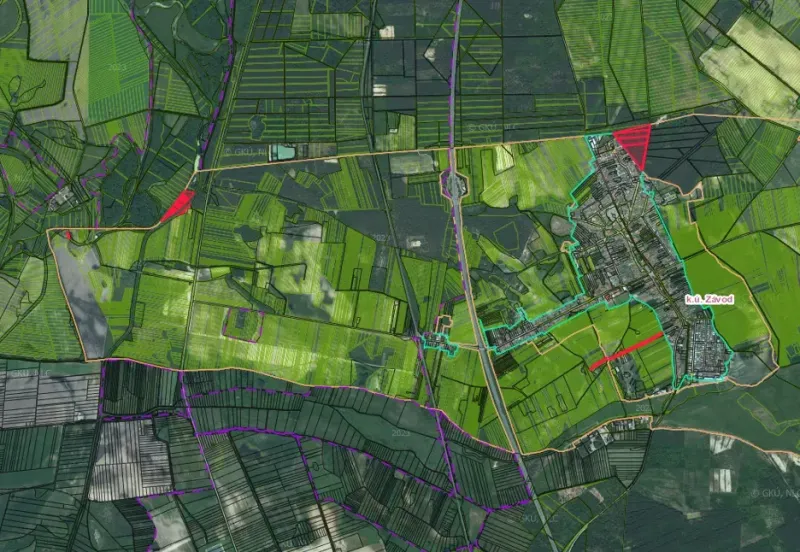 Aerial view of agricultural and forest lands in the village of Závod with road infrastructure.