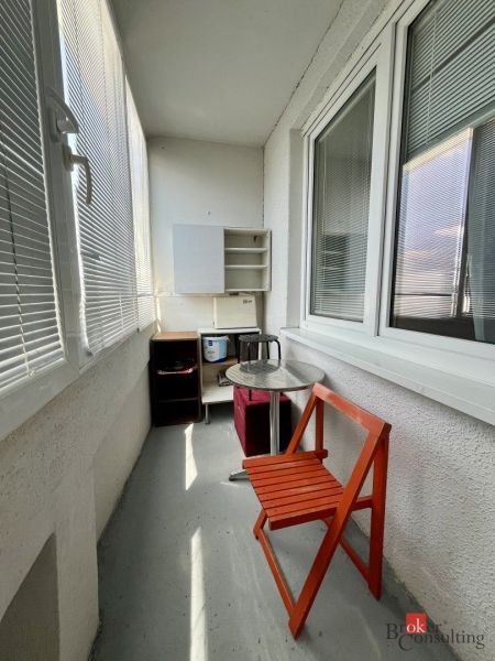 A balcony with seating and furniture in a studio apartment.