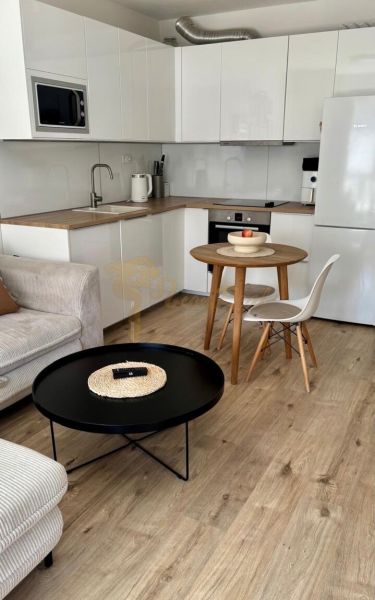 A kitchen corner with a round table and a floor with a wooden decor in a 2-room apartment.