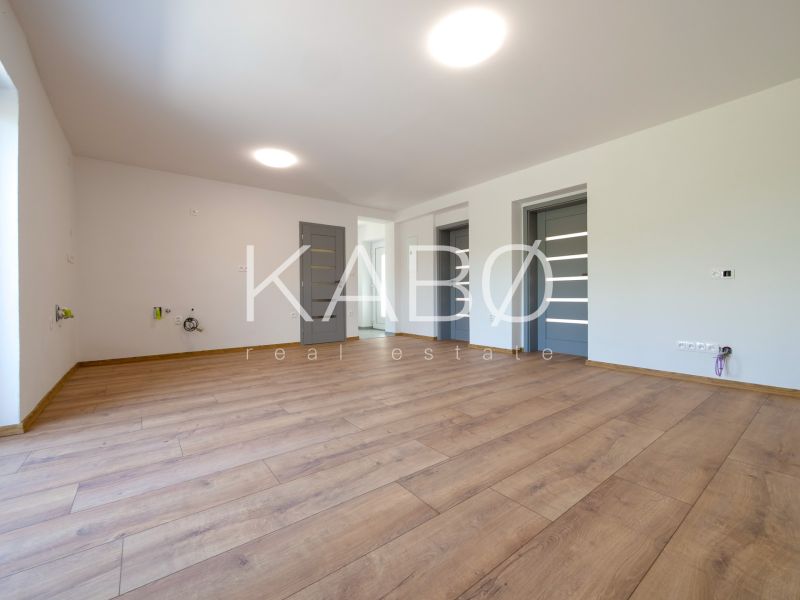 Living room in a family house with a wooden decor floor and white walls.