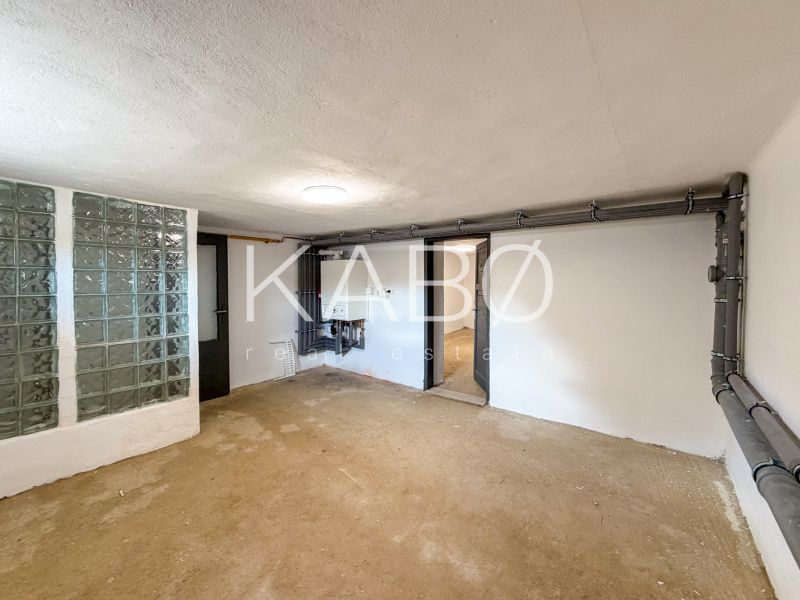 A room in a family house with a glass block wall and wiring on the wall.
