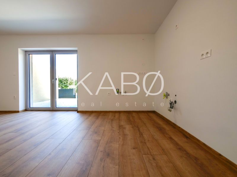 A room in a family house with a floor featuring a wooden decor and access to a terrace.