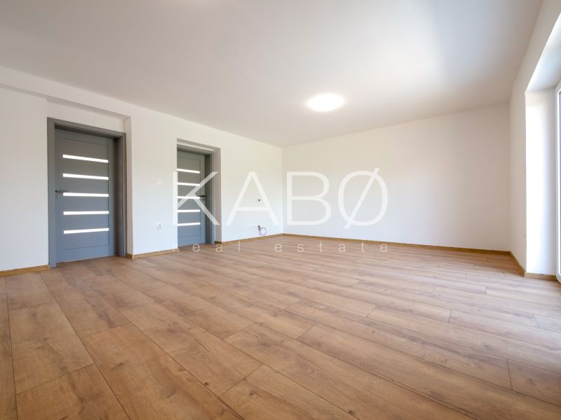 A room in a family house with a wooden decor floor and gray doors.
