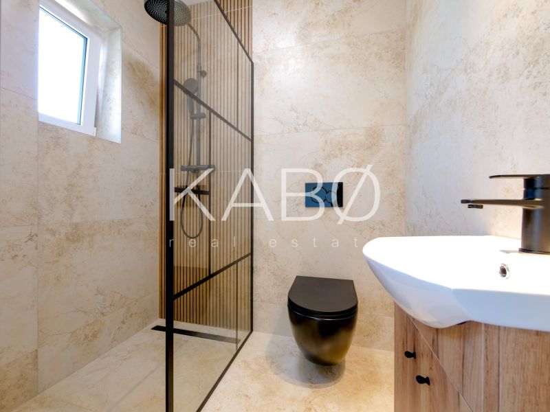 A bathroom in a family house with a modern shower and a black toilet.