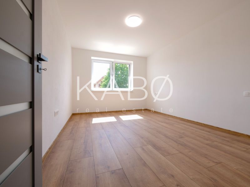A room in a family house with white walls and a floor with a wooden decor.