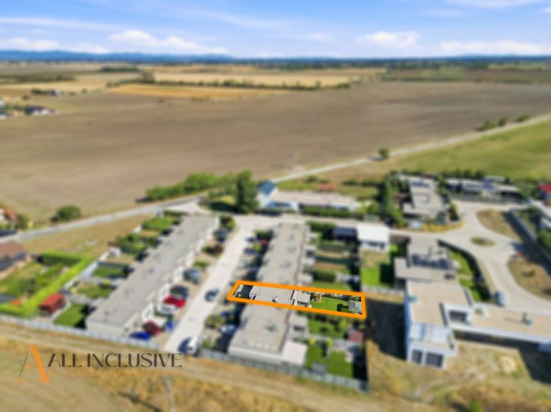 Aerial view of terraced family houses in Oľdza surrounded by fields.