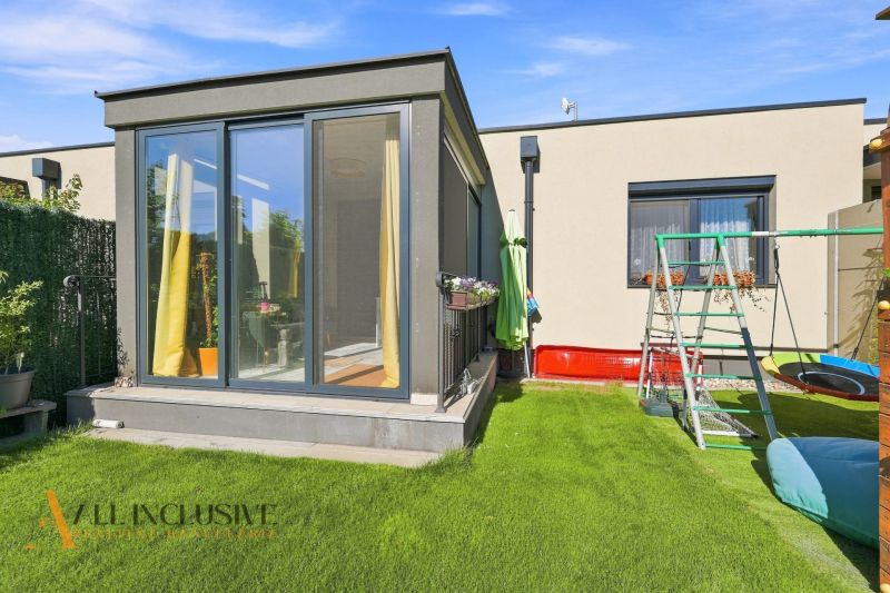 A family house in Oľdza with a terrace and a children's playground on green grass.