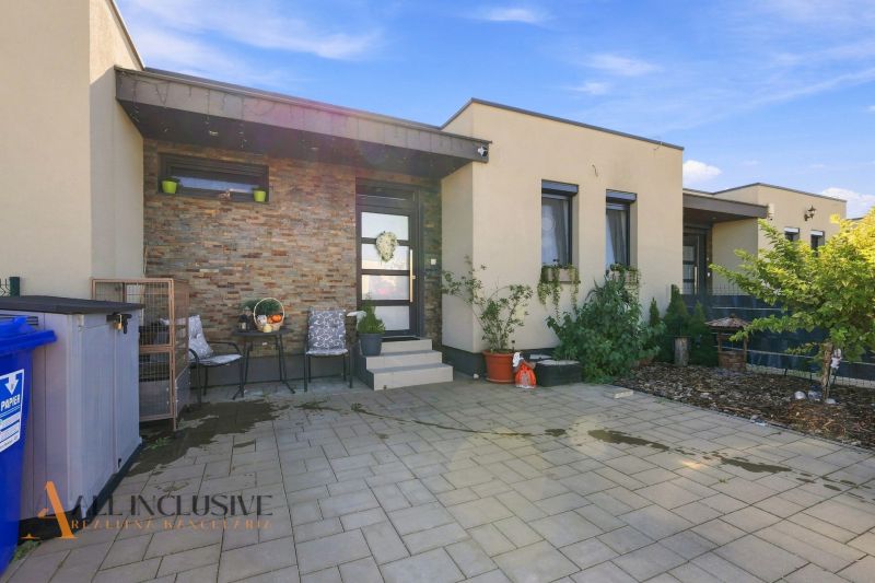 A family house in Oľdza with a terrace, flowers, and comfortable seating in front of the entrance.