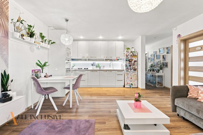 Interior of a family house with a kitchen, dining table, and floor with wooden decor.