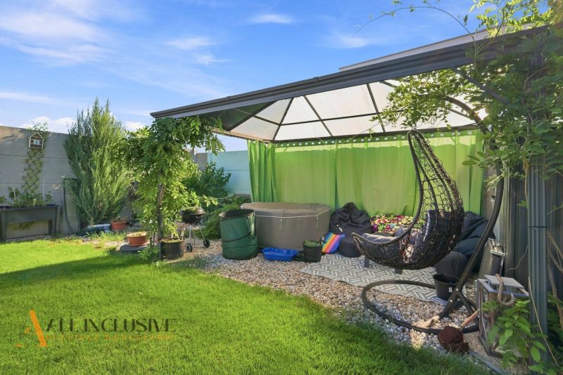 The garden of a family house in Oľdza with a pergola, curtains, and a swing for relaxation.