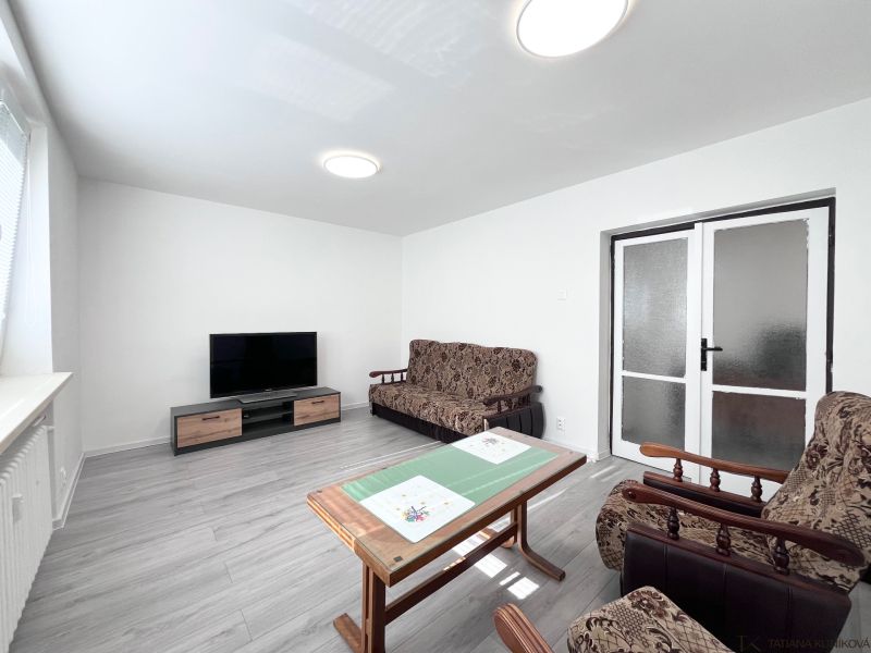 Living room in a 3-room apartment with a wooden decor floor and furnishings.