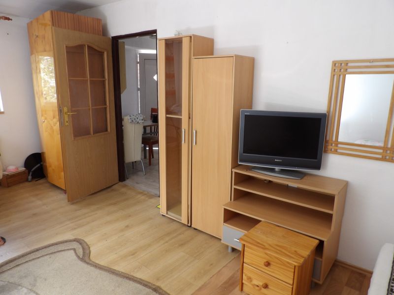 Living room in a two-room apartment with furniture and flooring featuring a wood design.