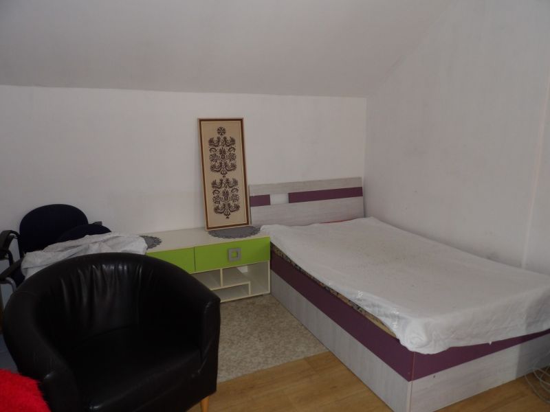 A room in a 2-room apartment with a bed, an armchair, and a floor with a wood decor.