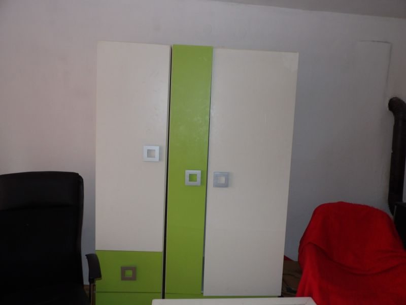 A wardrobe with colored doors and a black chair in a 2-room apartment.
