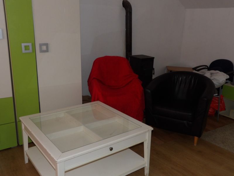 Living room in a two-room apartment with armchairs and a table on a wooden-decor floor.