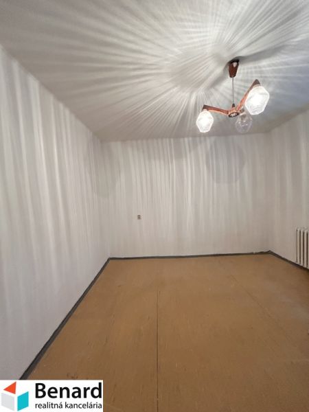 A room in a family house with white walls and a wooden decor floor.