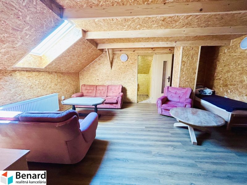 Living room of a family house with a wooden decor floor and pink armchairs.