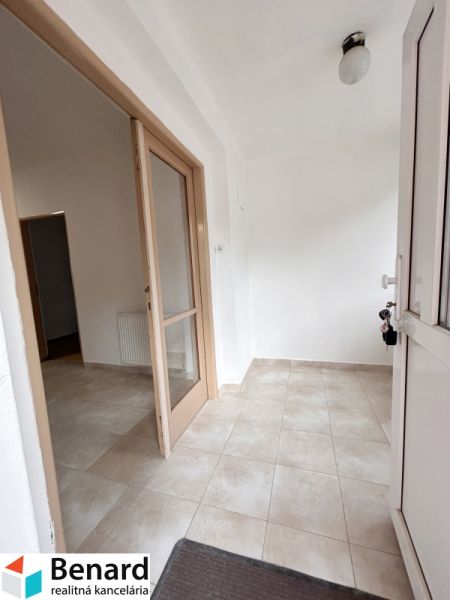 Entrance with light tiles and glass doors in a family house.