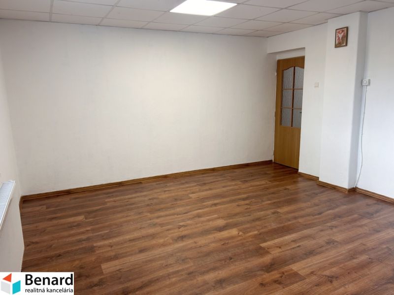 A room in a family house with white walls and a wooden decor floor.