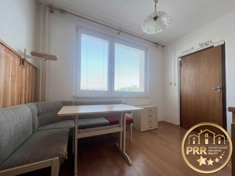 Dining area with seating and a wooden-patterned floor in a 2-room apartment.