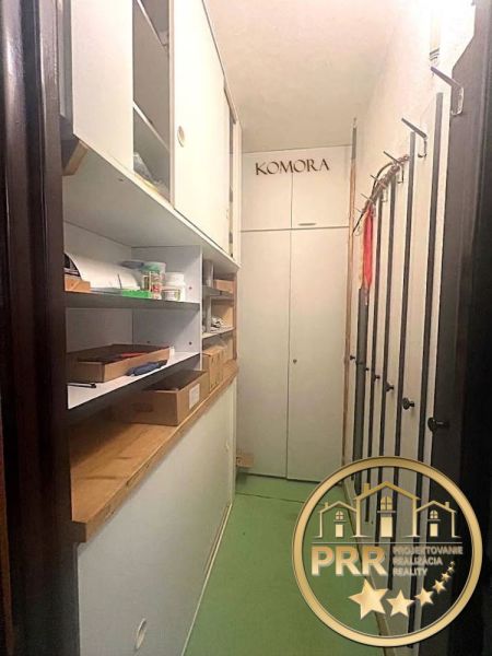 Storage space in a 2-room apartment with shelves and boxes, green floors.