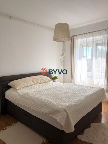 Bedroom in a 2-room apartment with a comfortable bed and a floor with a wooden decor.