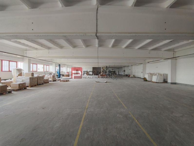 Extensive production facilities with numerous pallets and goods on a concrete floor.