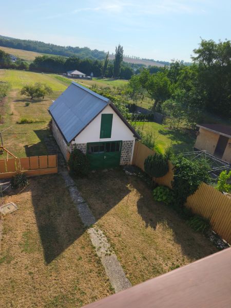 Garden and construction at a family house in Jelenec, surrounded by fields and trees.