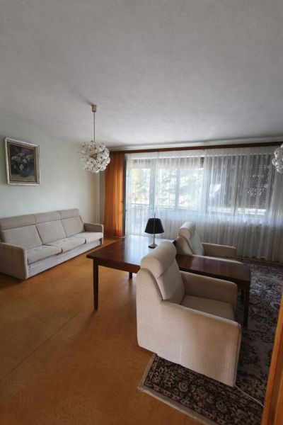 Living room in a family house with comfortable seating and a large window.