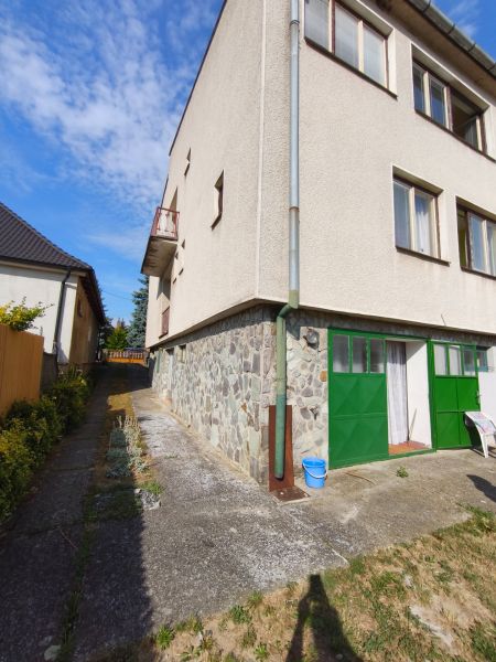 A family house in Jelenec with stone cladding and green doors.