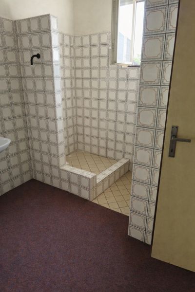 A bathroom in a family house with retro tiles and a shower corner.
