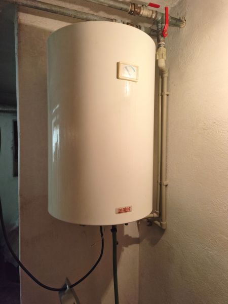 Wall-mounted hot water tank in a family house with very simple valves.