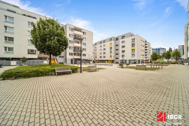 In Bratislava - Dúbravka at Pri Hrubej lúke, there is a square with apartments and benches.