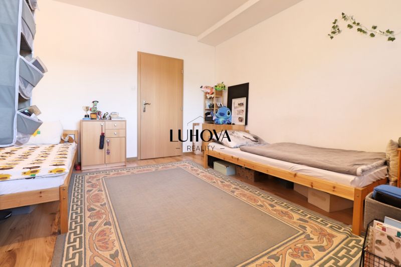 Children's room in a two-room apartment with two beds and a carpet on the floor with a wooden decor.