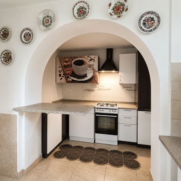 A kitchen in a family house with an arched entrance, decorated with plates and modern details.