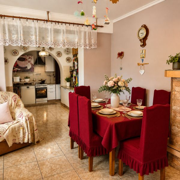 Dining room in a family house with red placemats, a kitchen, and decorations with an antique wall clock.