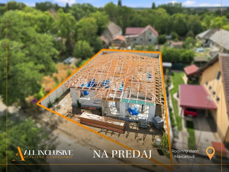 A family house under construction in Marcelová with a completed wooden roof structure.
