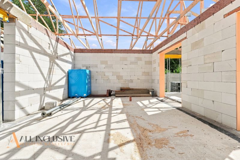 Construction of a family house in Marcelová with exposed wooden trusses and unfinished walls.