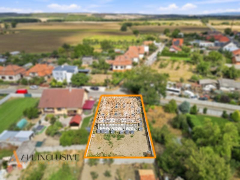 A family house under construction in Marcelová, surrounded by gardens and nature.