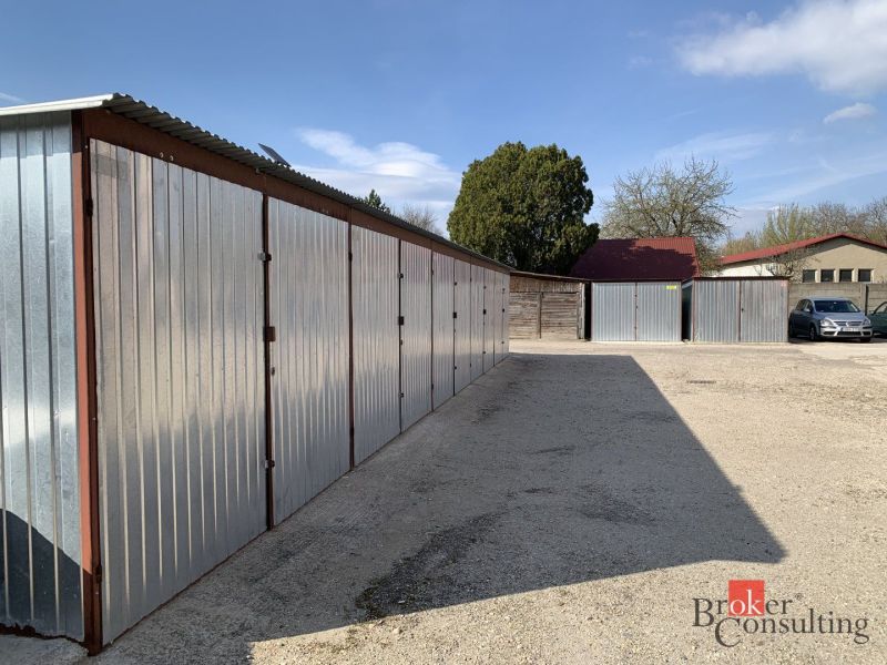 Iron garages on Železničná Street in Šahy. Parking space and cars nearby.