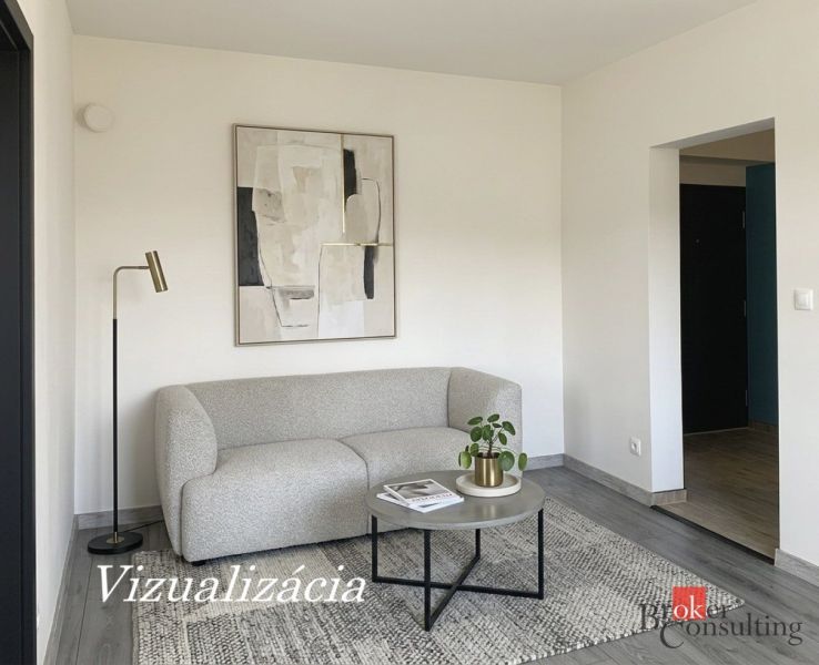 A room in a one-room apartment with a couch, a painting, and a floor with a wood decor.