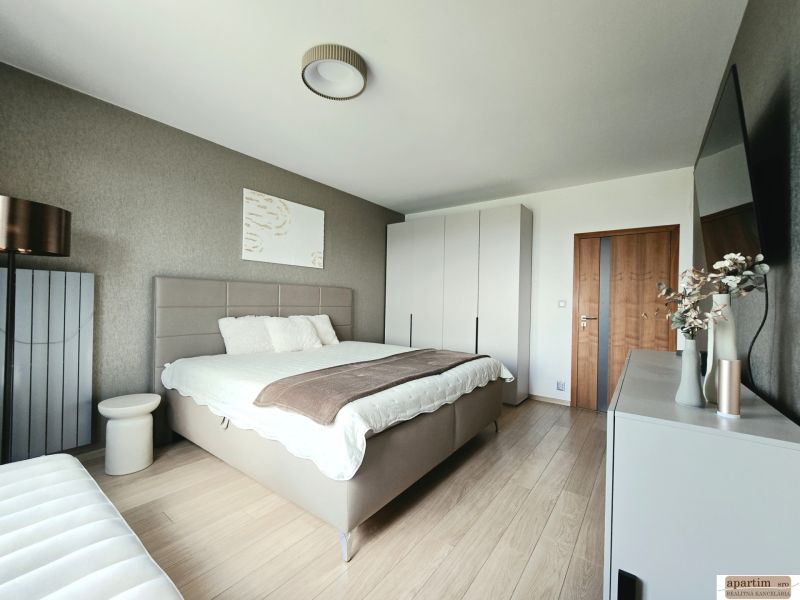 Bedroom in a 4-room apartment with a bed, cabinet, and wooden decor flooring.