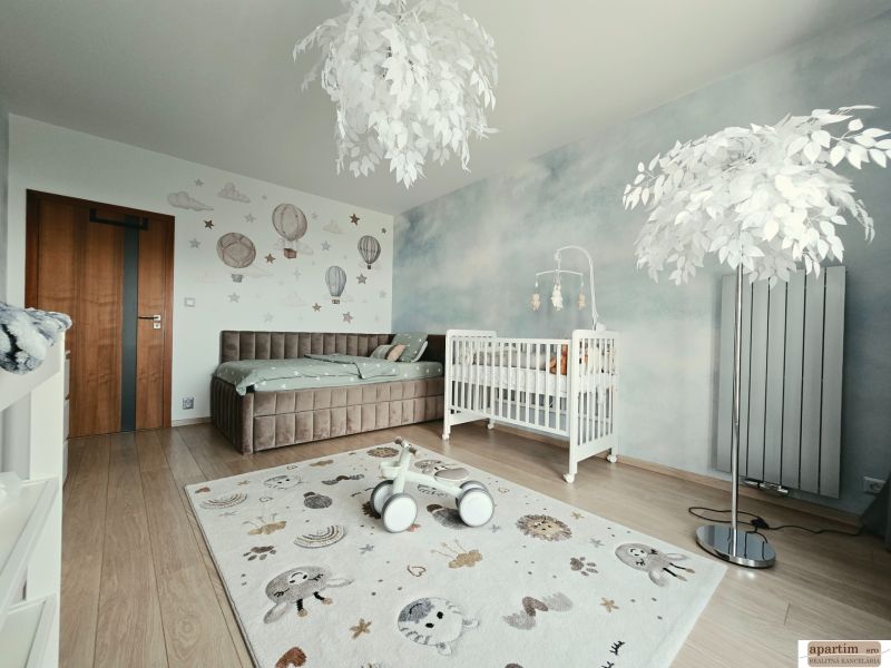 Children's room with wall decorations, wood-patterned flooring, and a white crib in a 4-room apartment.