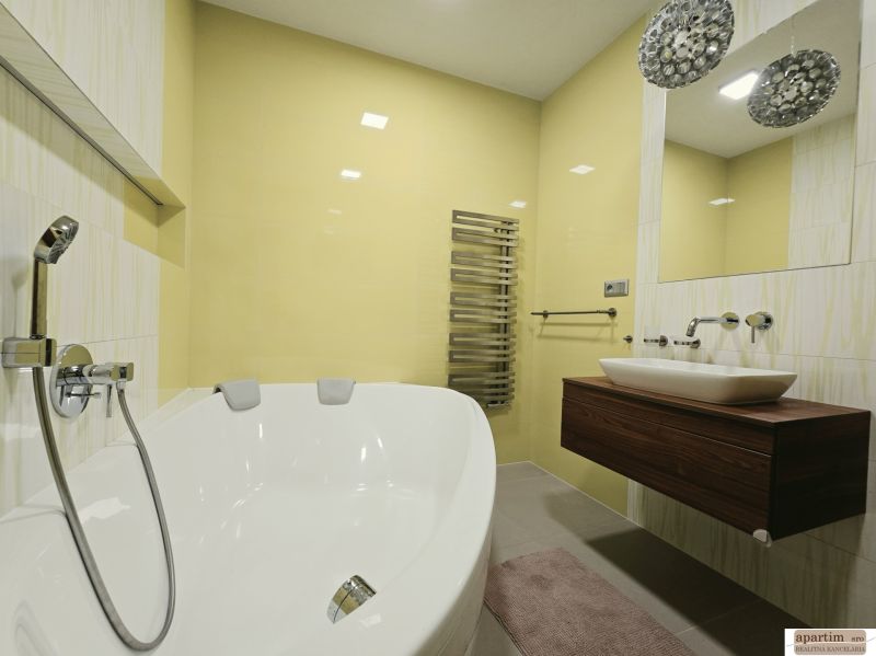 Bathroom with a bathtub in a 4-room apartment, with yellow tiles and a modern sink.