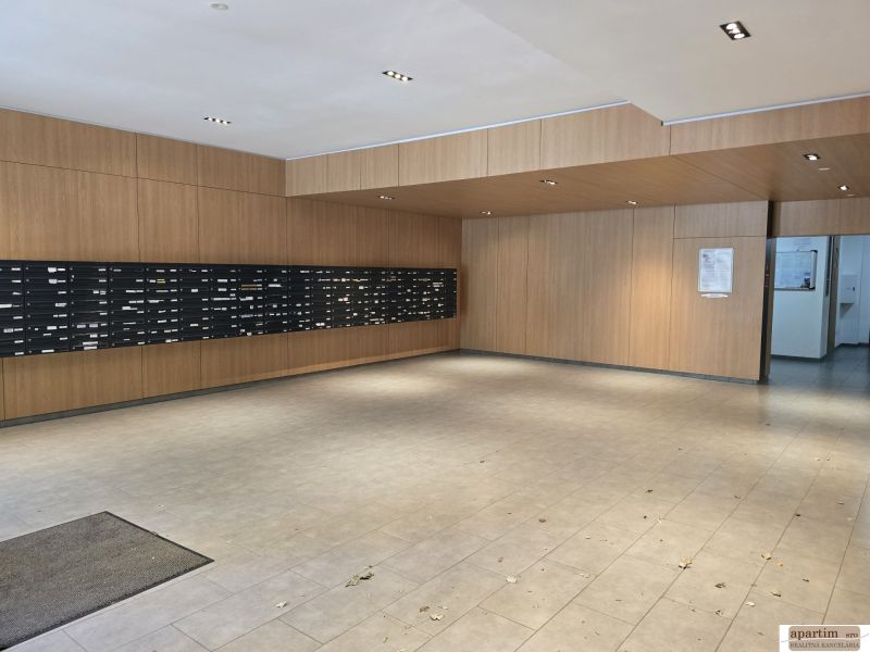 Entrance hall with mailboxes and wooden wall paneling in a 4-room apartment.