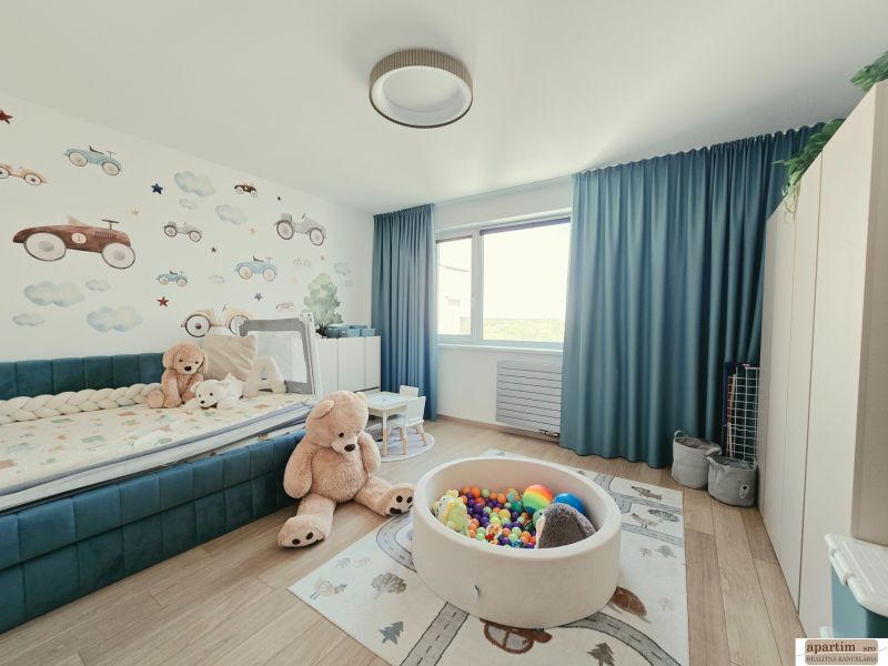 Children's room in a 4-room apartment with a wooden decor floor, toys, and wall decoration.